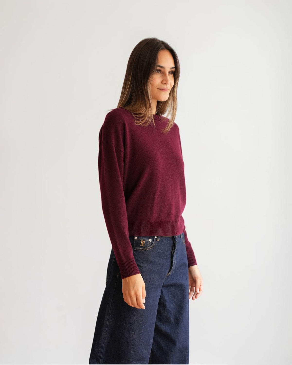 Seitenansicht des Allude U-Boot-Pullovers in Burgundy aus Cashmere am Model