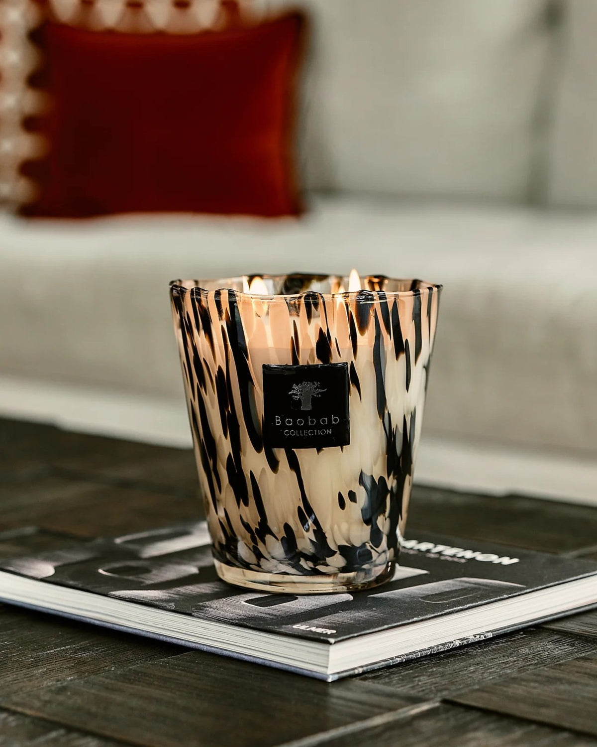 Baobab Collection Duftkerze Pearls Black in Signature Max 16 auf einem Bildband