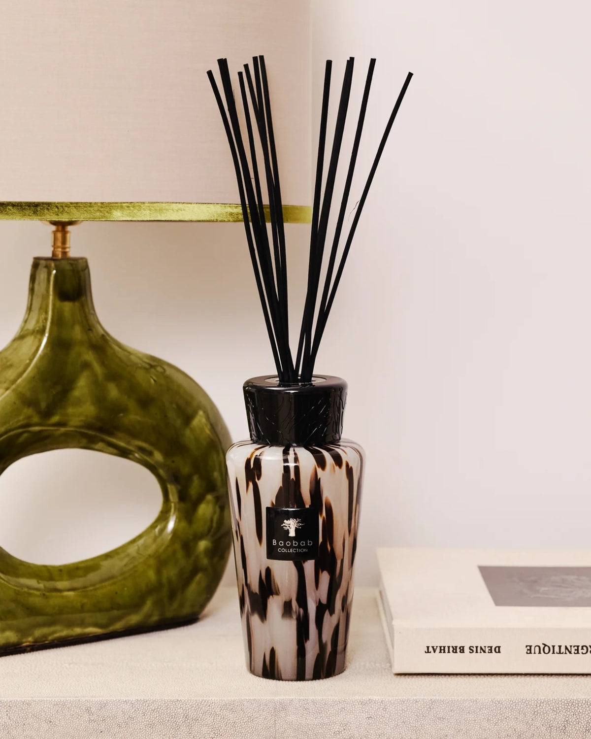 Baobab Collection Raumduft-Diffuser Pearls Black 500 ml neben einer grünen Tischleuchte im Interieur