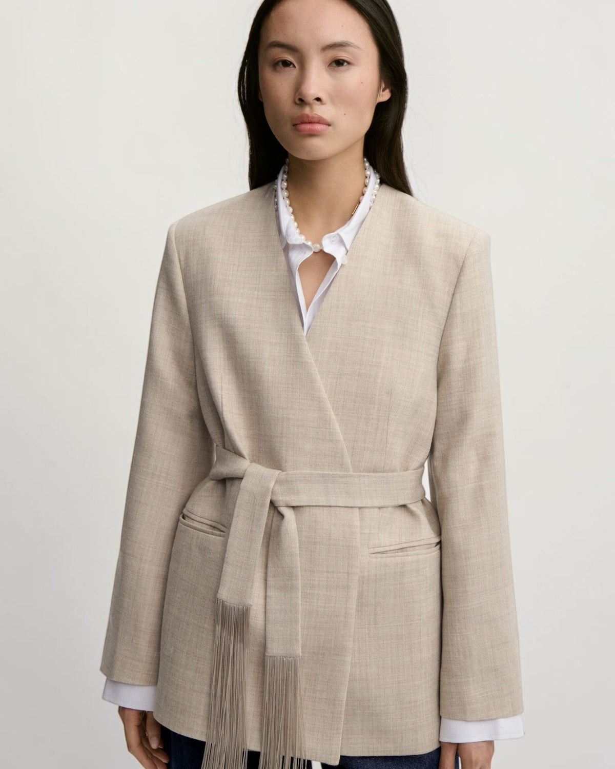Kragenlose Front und gebundener Fransengürtel des By Malene Birger Blazers in Graubraun Melange am Model