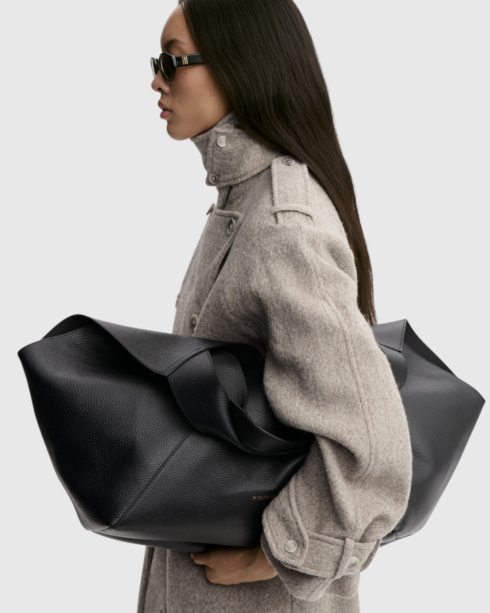 By Malene Birger große Tote Bag aus schwarzem Rindsleder seitlich am Model getragen