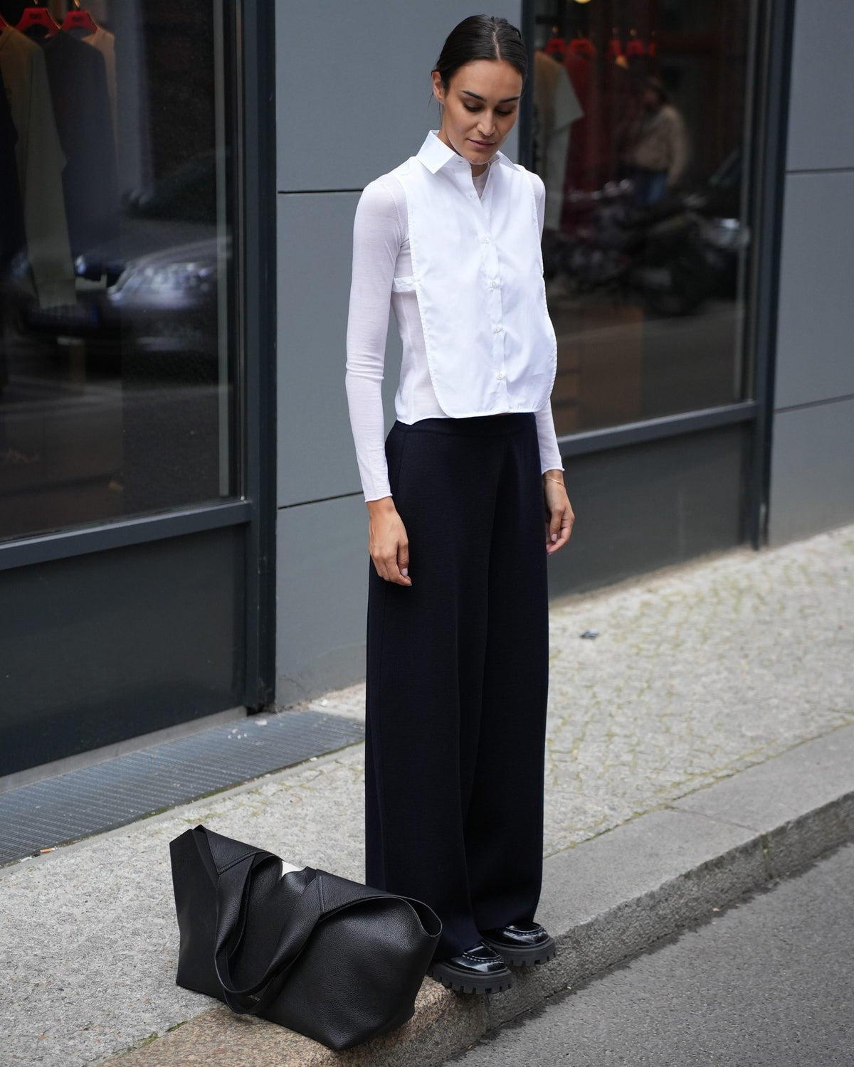 By Malene Birger große Tote Bag aus schwarzem Leder neben dem Model auf dem Boden