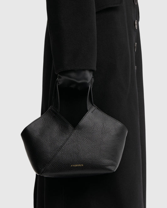 By Malene Birger kleine schwarze Ledertasche mit breiten Henkeln seitlich am Model getragen