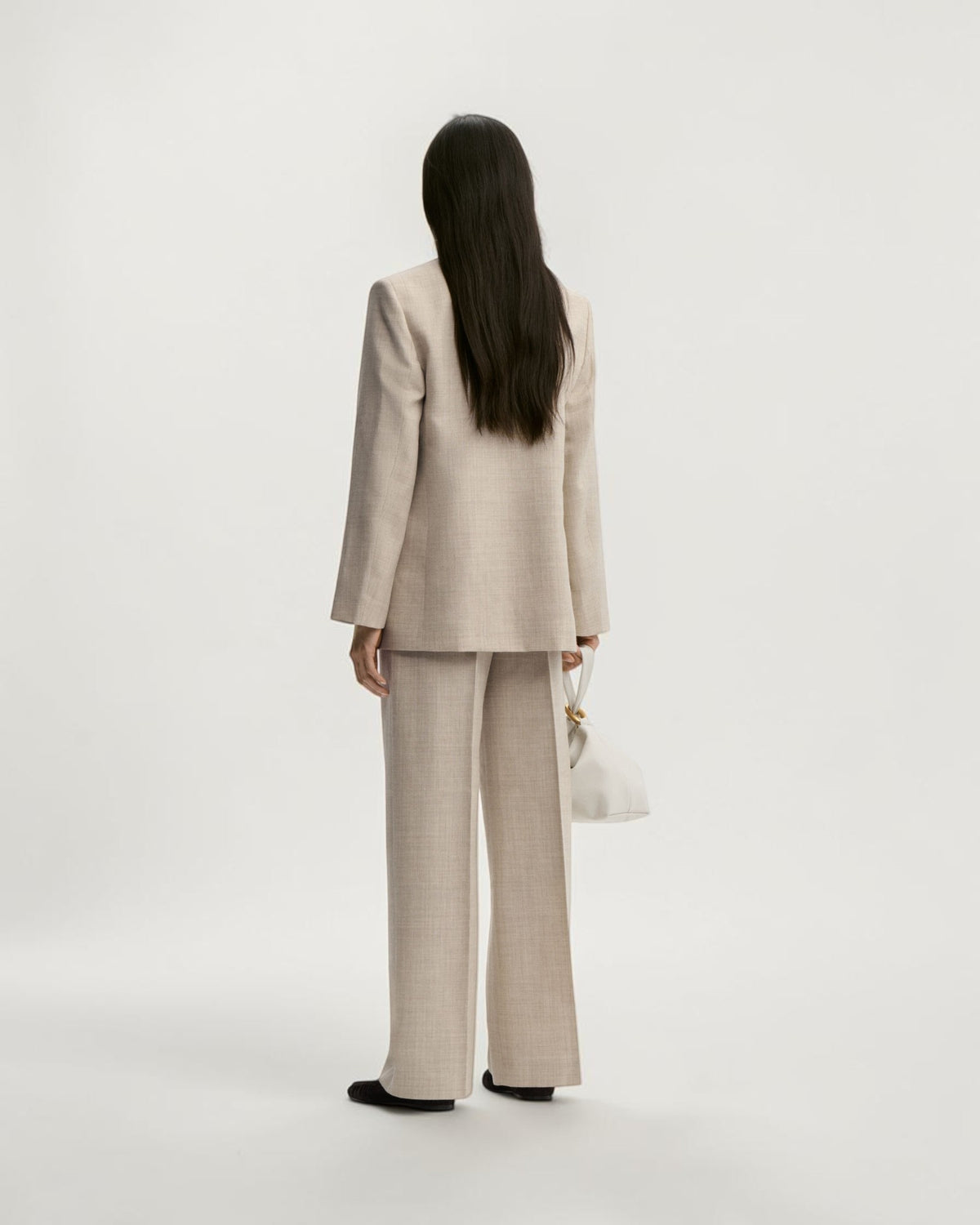 By Malene Birger weite Wollhose in Graubraun Melange von hinten am Model mit locker fallendem Bein