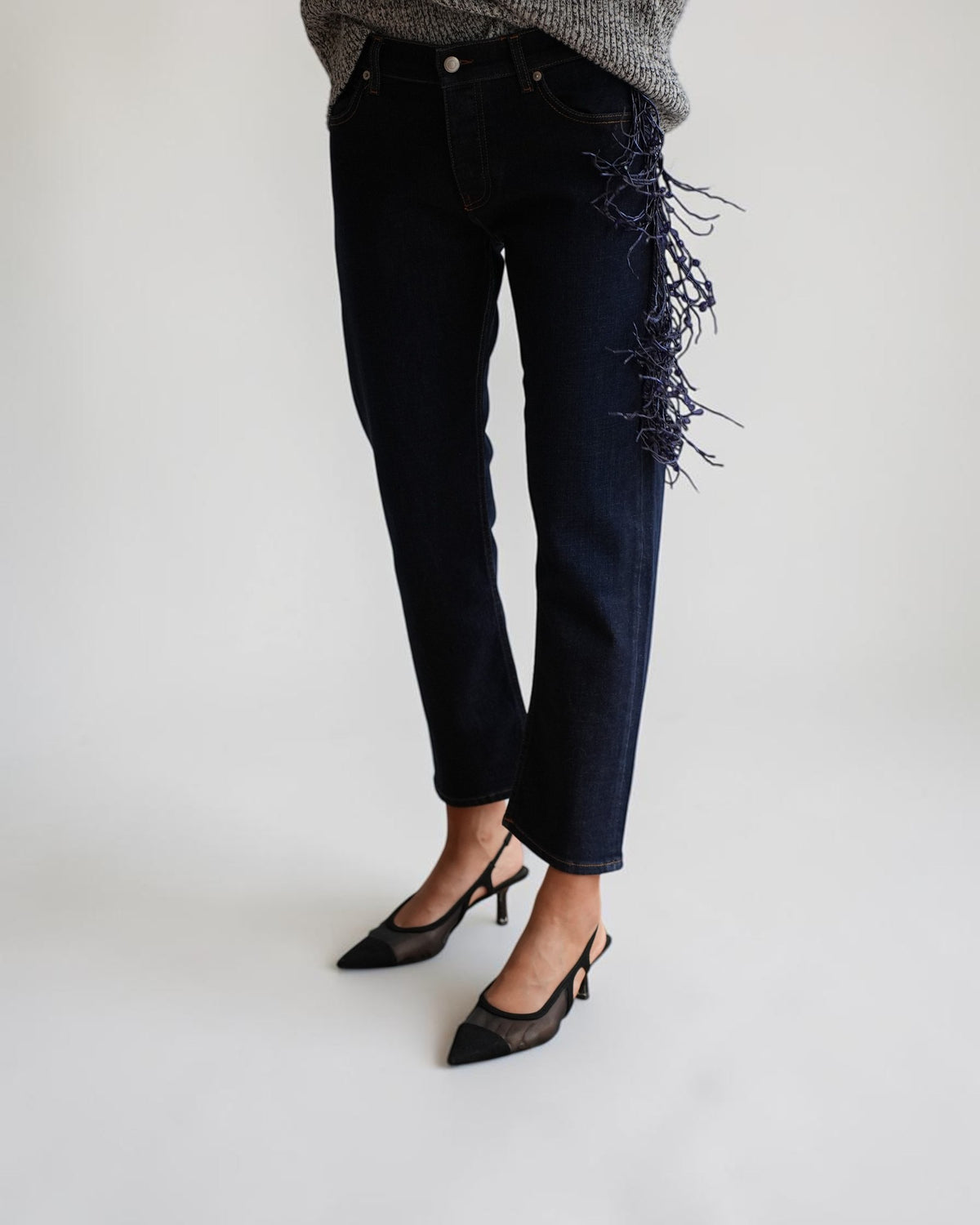 Detail der dunkelblauen Circus Hotel Straight-Leg Jeans mit Schmuckfransen in Bewegung am Model