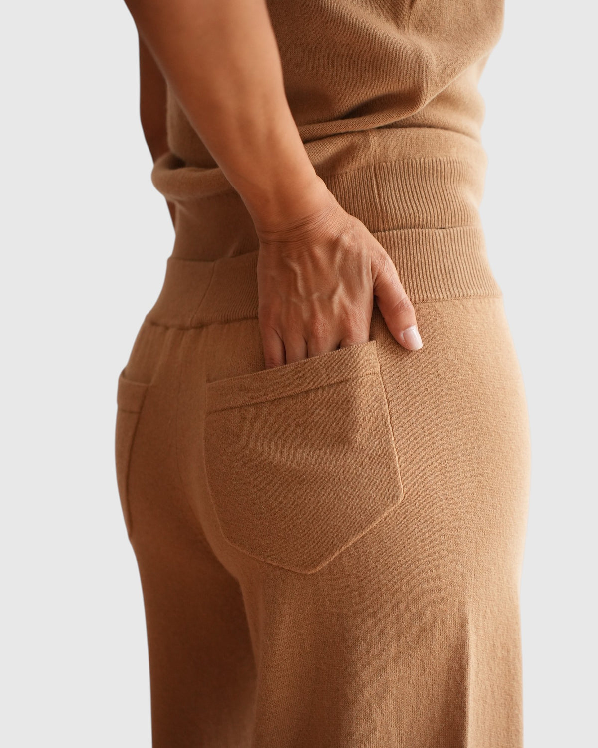 Detail der aufgesetzten Gesäßtasche und des Rippbunds der beigefarbenen Circus Hotel Jogger-Hose am Model.