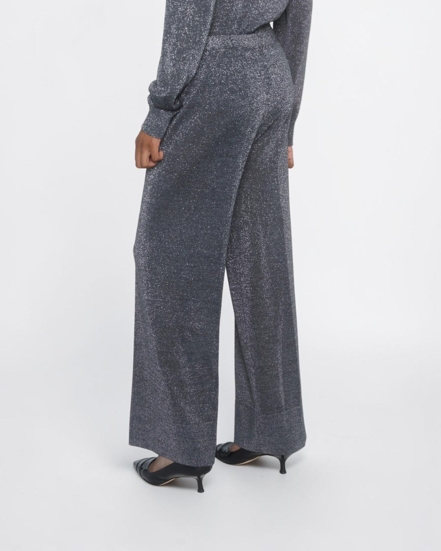 Circus Hotel Cropped Lamé-Hose in Grau am Model von hinten mit weitem Bein und metallischem Schimmer