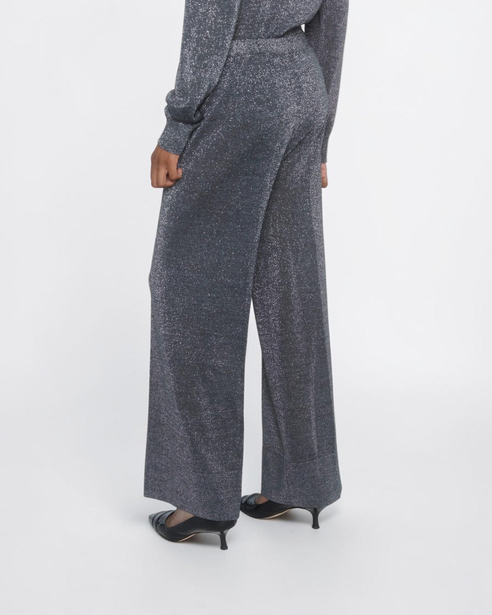 Circus Hotel Cropped Lamé-Hose in Grau am Model von hinten mit weitem Bein und metallischem Schimmer