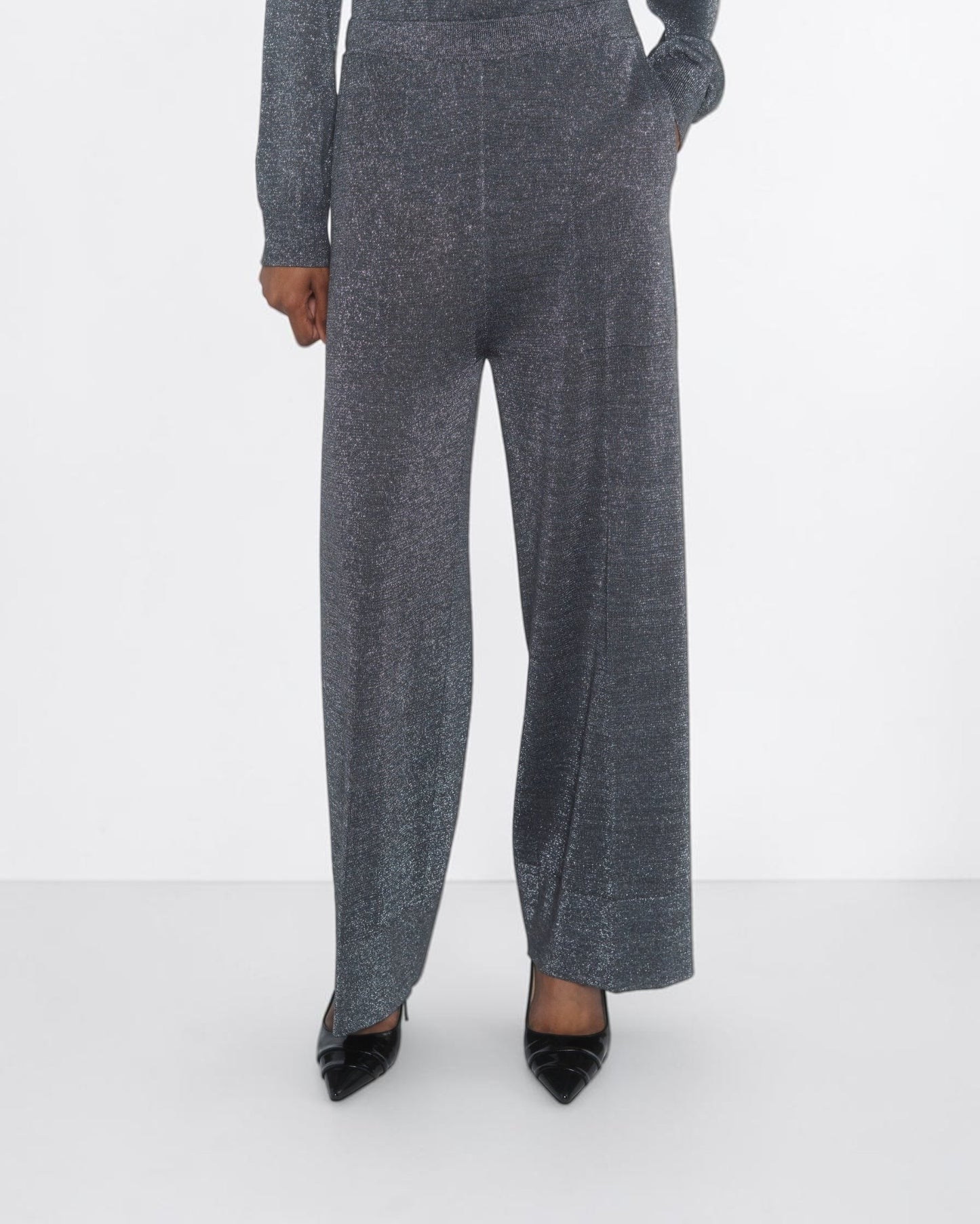 Circus Hotel Cropped Lamé-Hose in Grau am Model von vorne mit weitem Bein und sichtbaren Seitentaschen