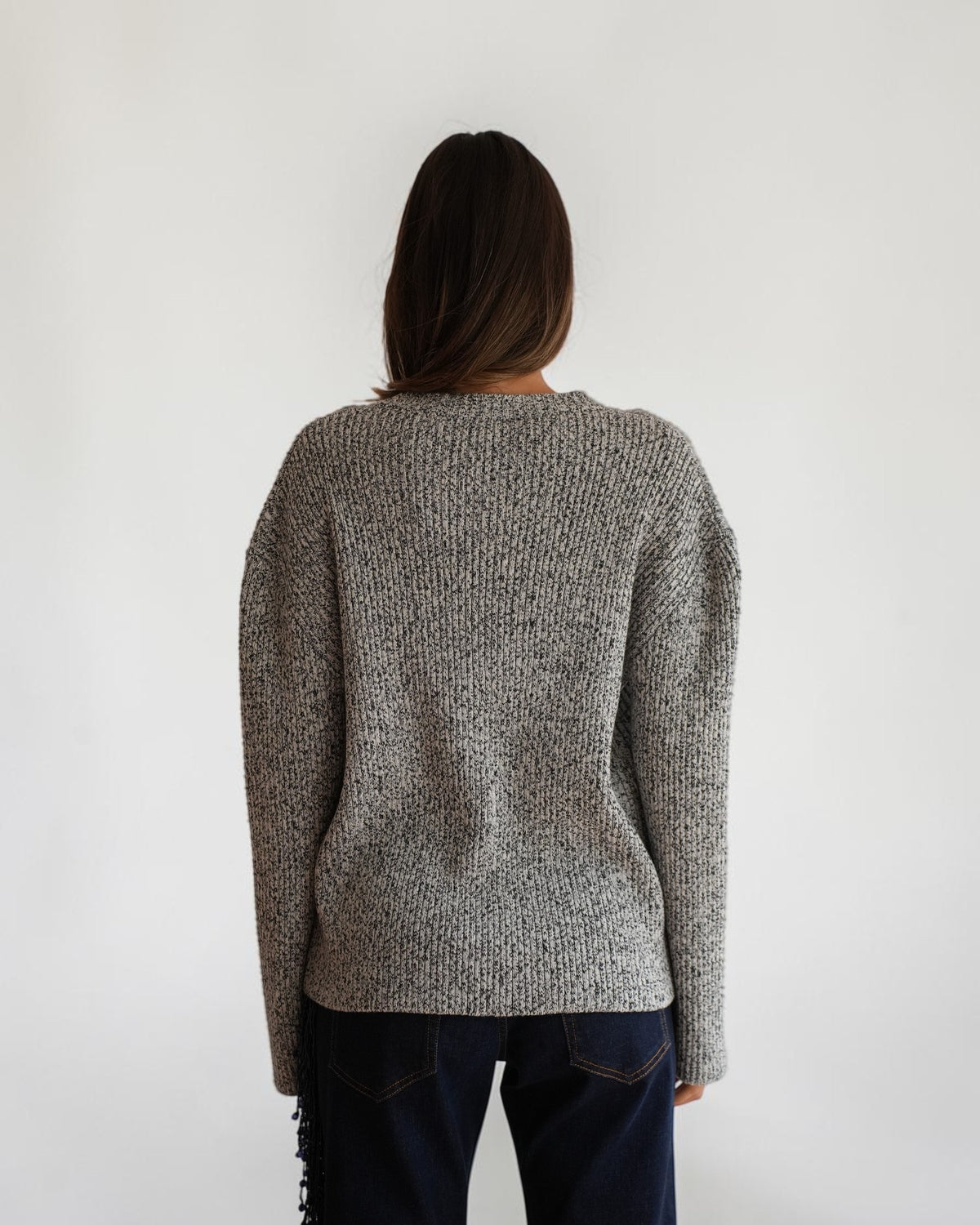 Back view of the black and white melange Courrèges sweater on a model, showing the dropped shoulders