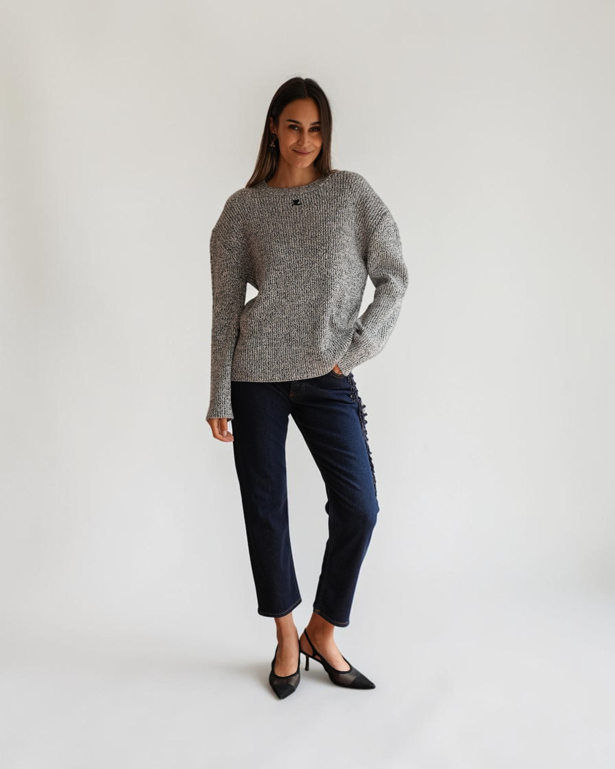 Black and white melange oversized Courrèges sweater on a model from the front, styled with dark jeans