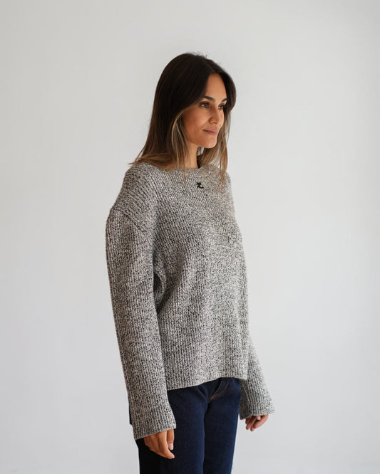 Schwarz-weiß melierter Courrèges-Pullover am Model in Dreiviertelansicht mit weiten Ärmeln