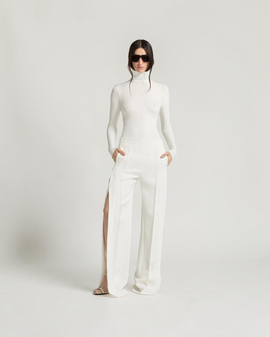Weißer Jersey-Body von Courrèges am Model von vorn, kombiniert mit einer weit geschnittenen weißen Hose