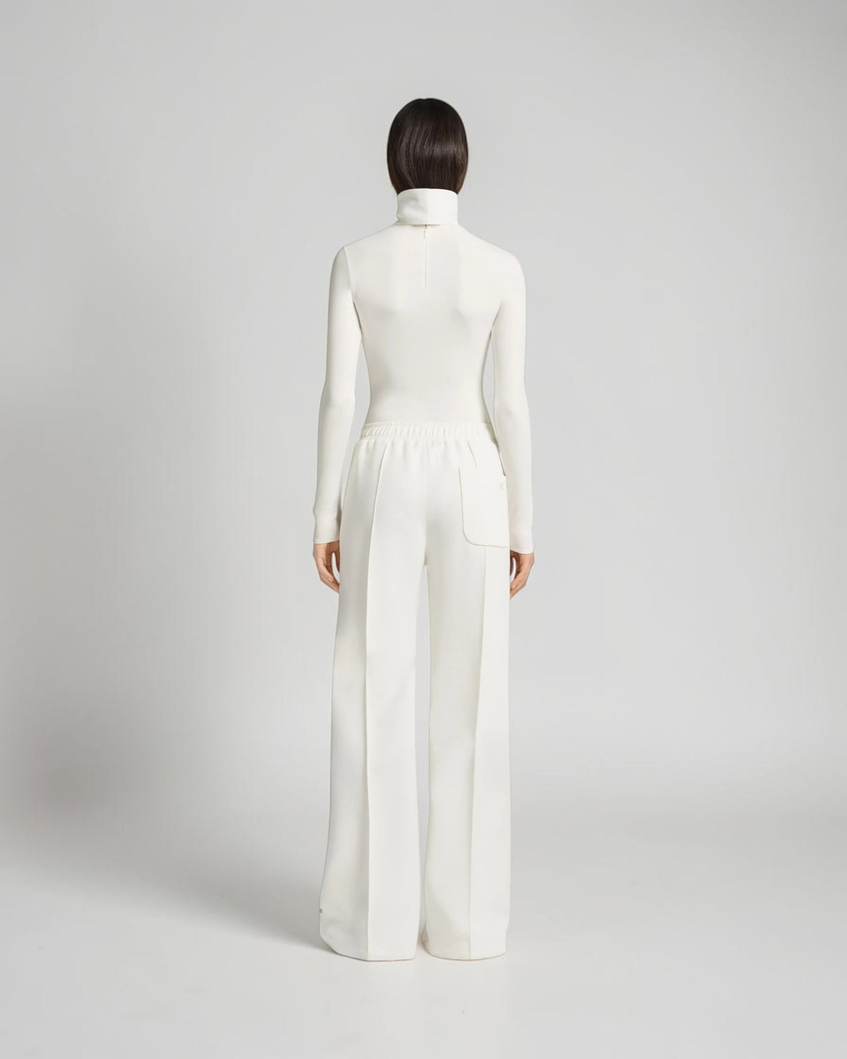 Weißer Jersey-Body von Courrèges am Model von hinten mit hohem Kragen, langen Ärmeln und schmaler Silhouette
