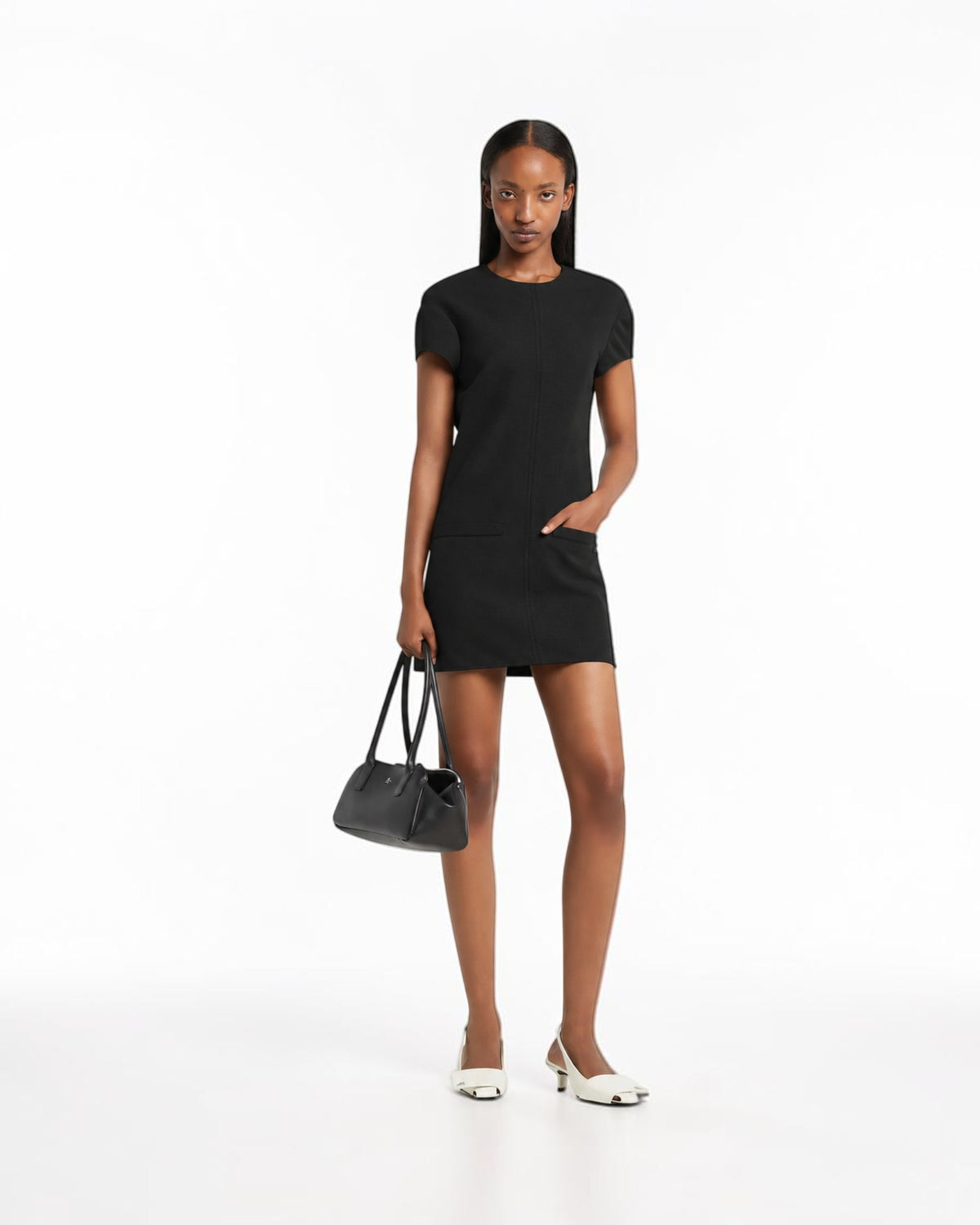 Courrèges black Heritage mini dress on the model from the front with a gently flared skirt