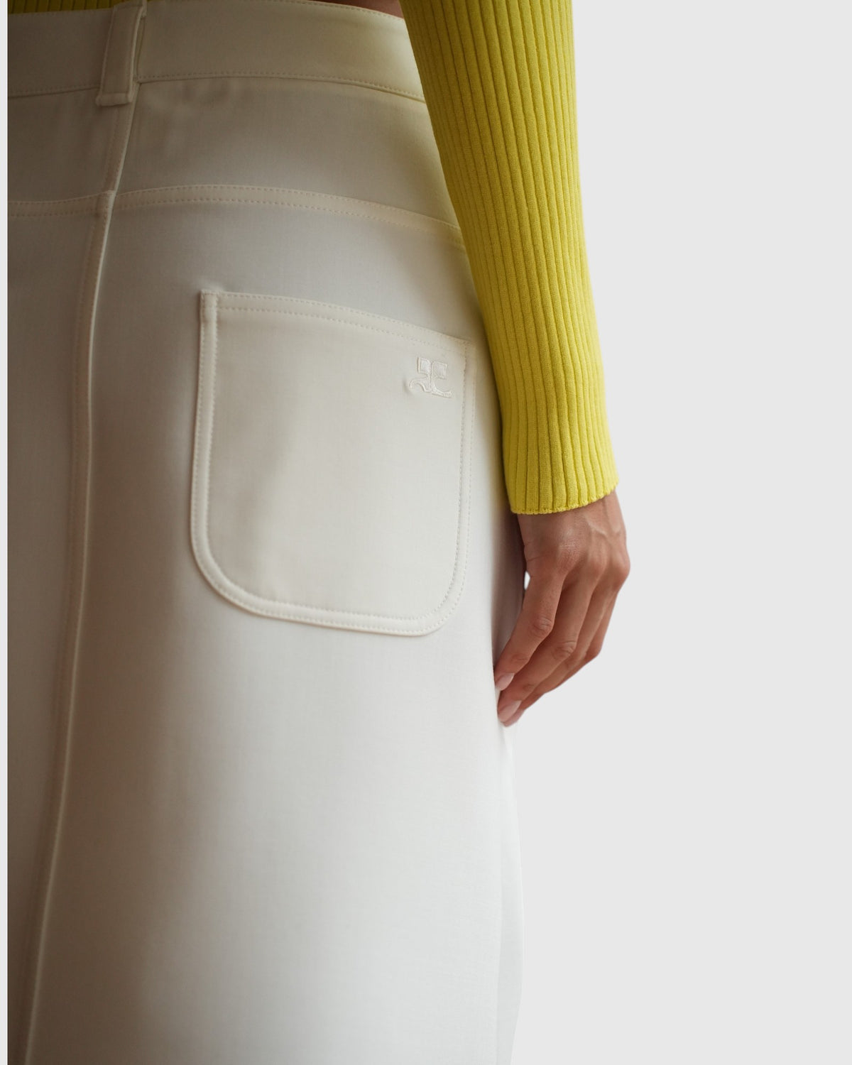 Rechte Gesäßtasche des weißen Courrèges Bleistiftrocks mit tonaler Logostickerei