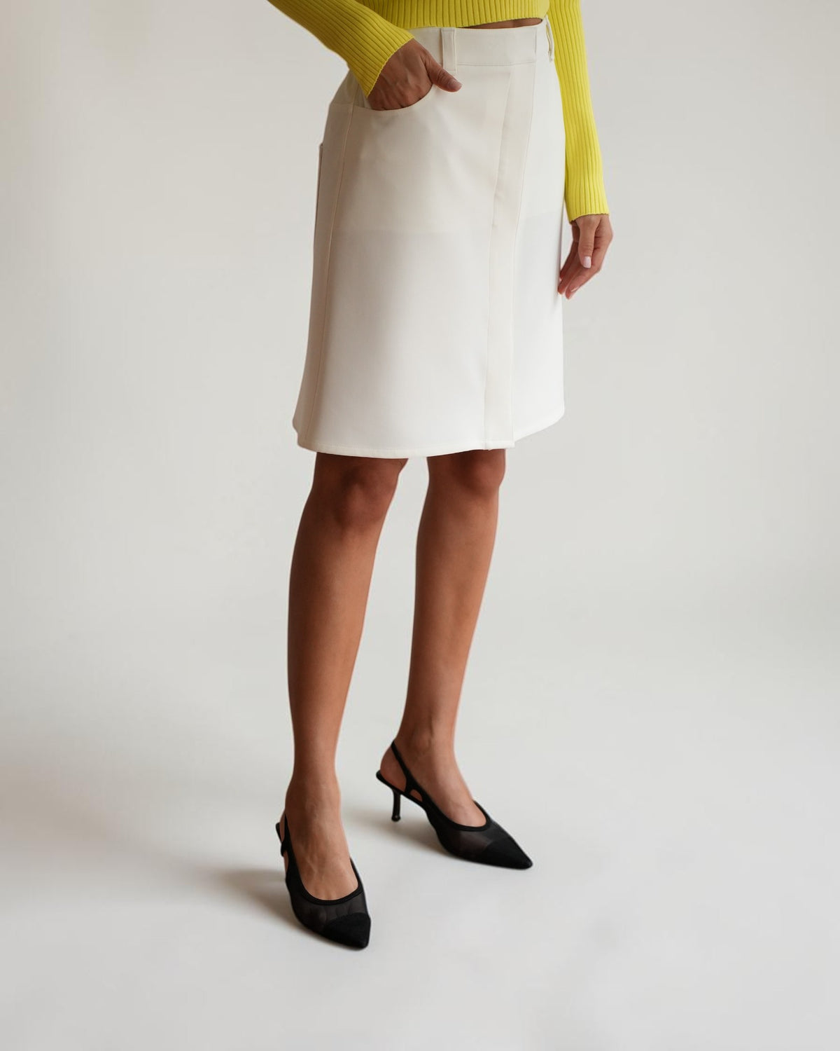 White Courrèges pencil skirt on a model with a close-up of the waistband and front pocket