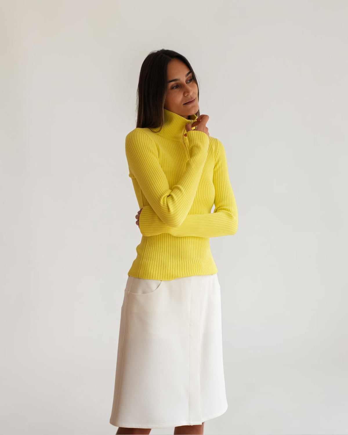White Courrèges pencil skirt on a model, styled with a yellow ribbed sweater