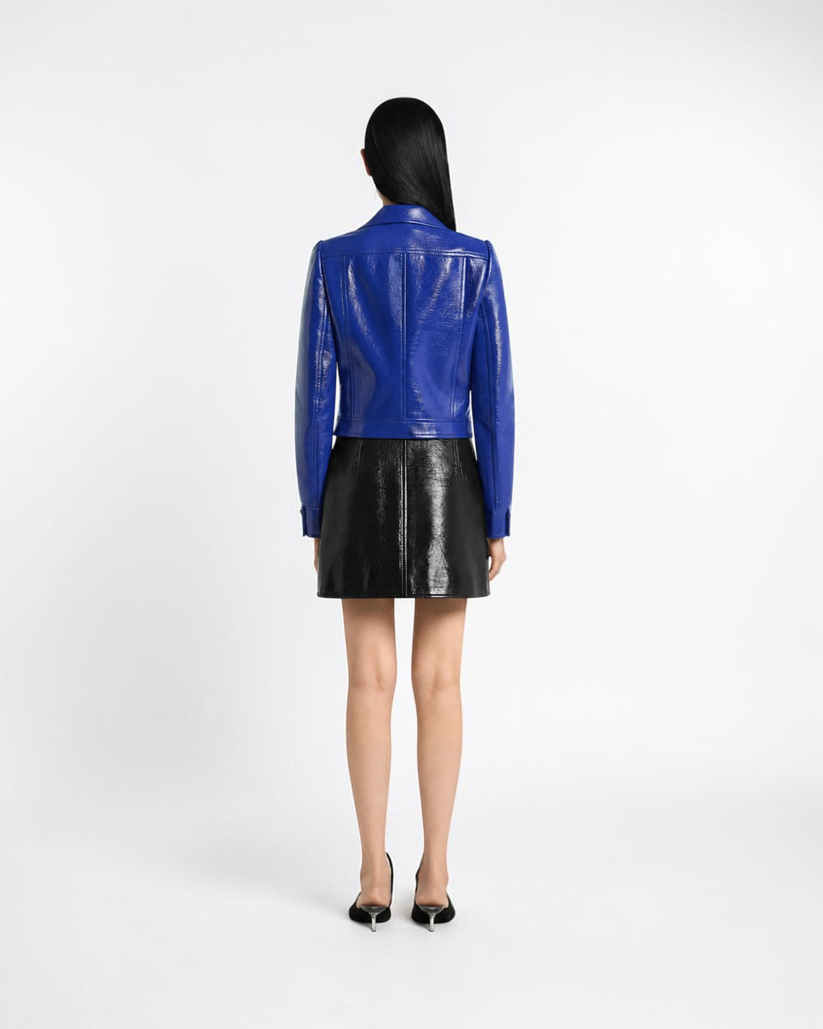 Courrèges black vinyl mini skirt on the model from the back with a slightly flared shape
