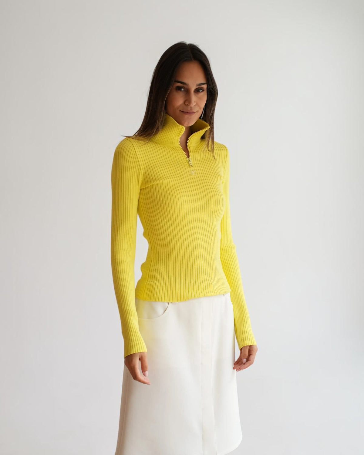 Gelber Rippstrick-Pullover mit teilweise geöffnetem Zip-Kragen und langen Ärmeln, nähere Vorderansicht am Model.