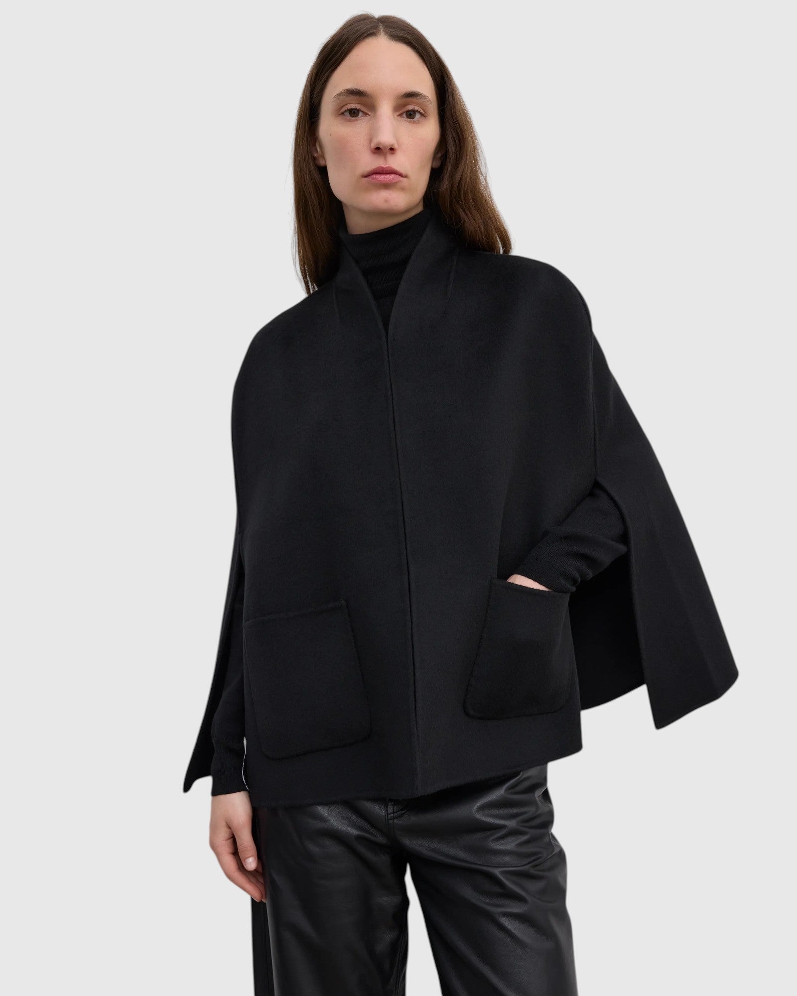 Detailansicht des schwarzen Wollcapes mit aufgesetzten Fronttaschen