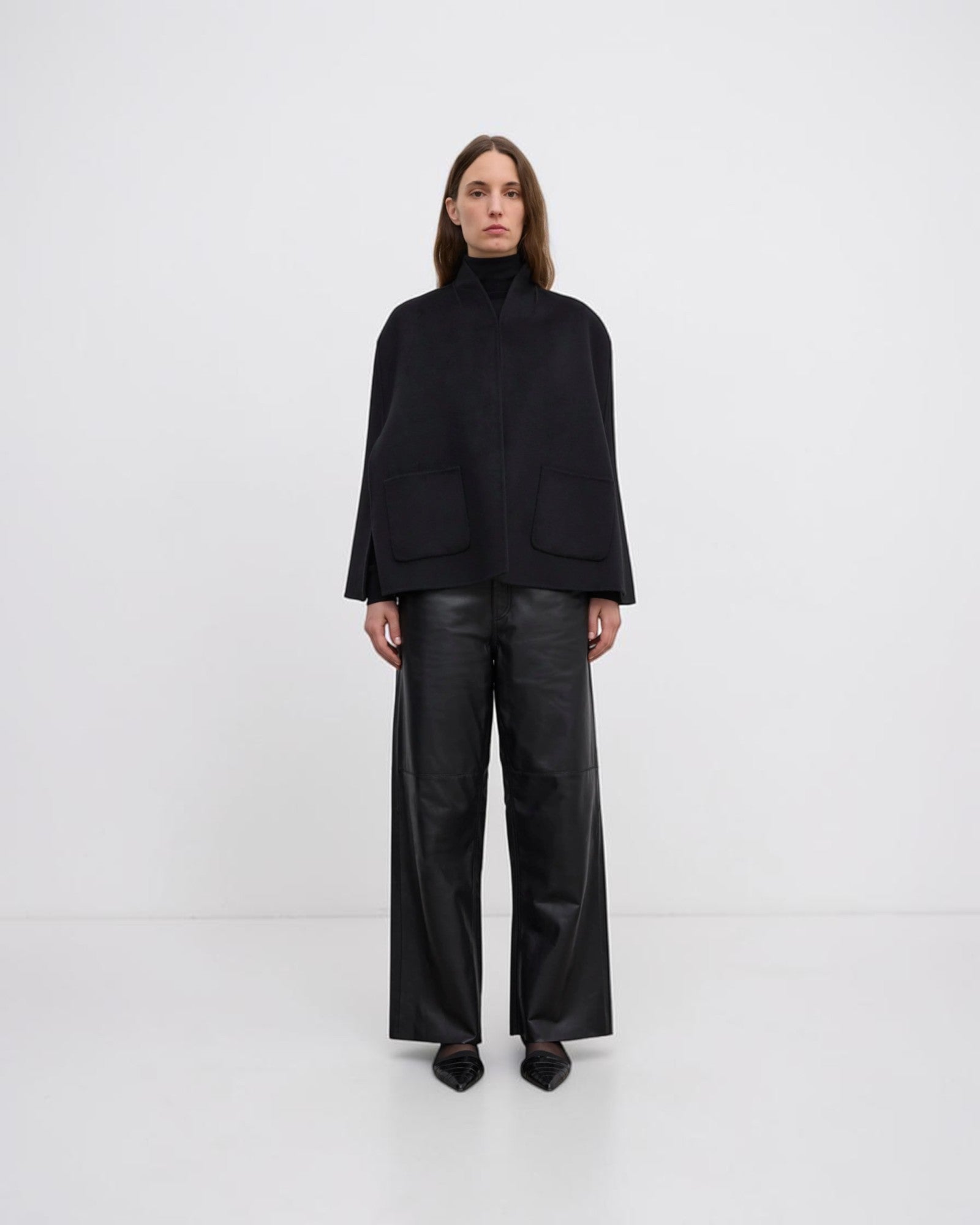 Model trägt schwarzes handgenähtes Wollcape von House of Dagmar in Vorderansicht