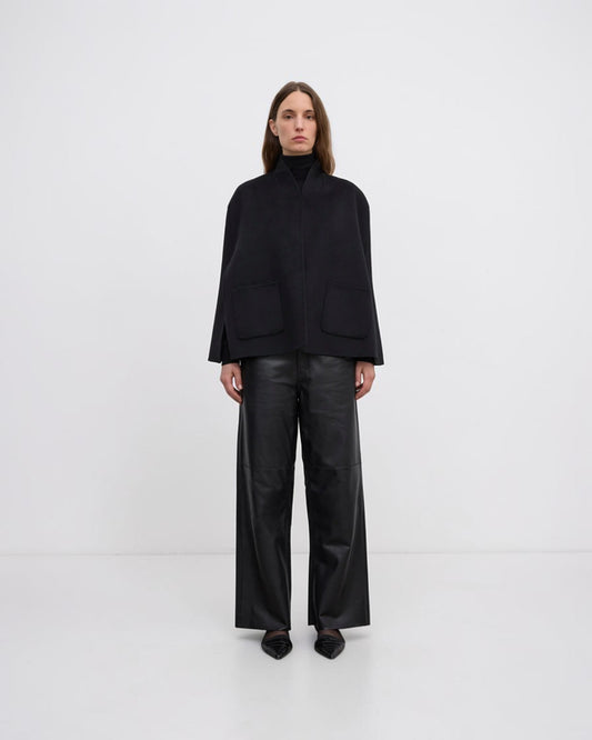 Model trägt schwarzes handgenähtes Wollcape von House of Dagmar in Vorderansicht