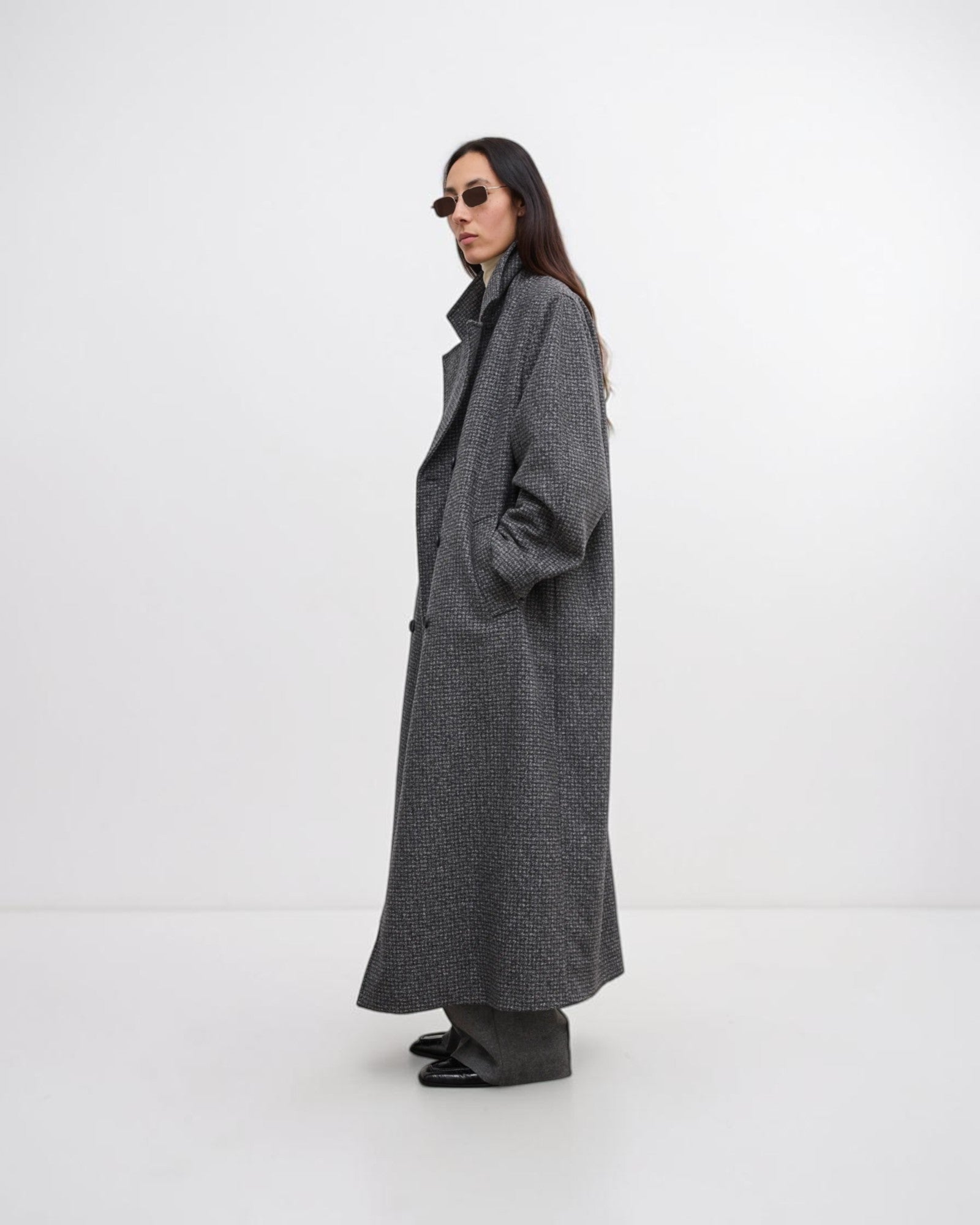 Model trägt grauen Oversized-Wollmantel in Seitenansicht