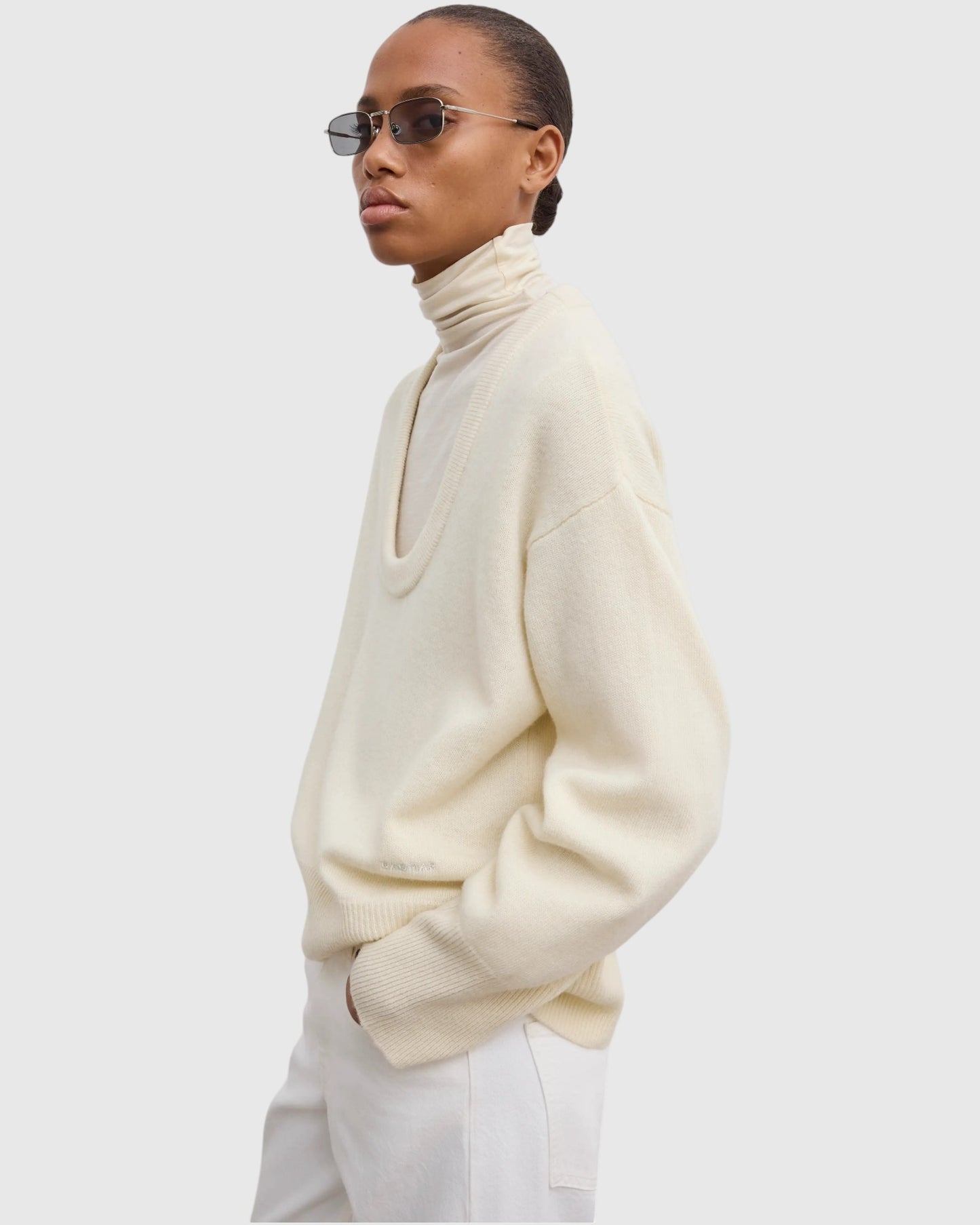 Model trägt cremeweißen Oversized-Wollpullover in Seitenansicht
