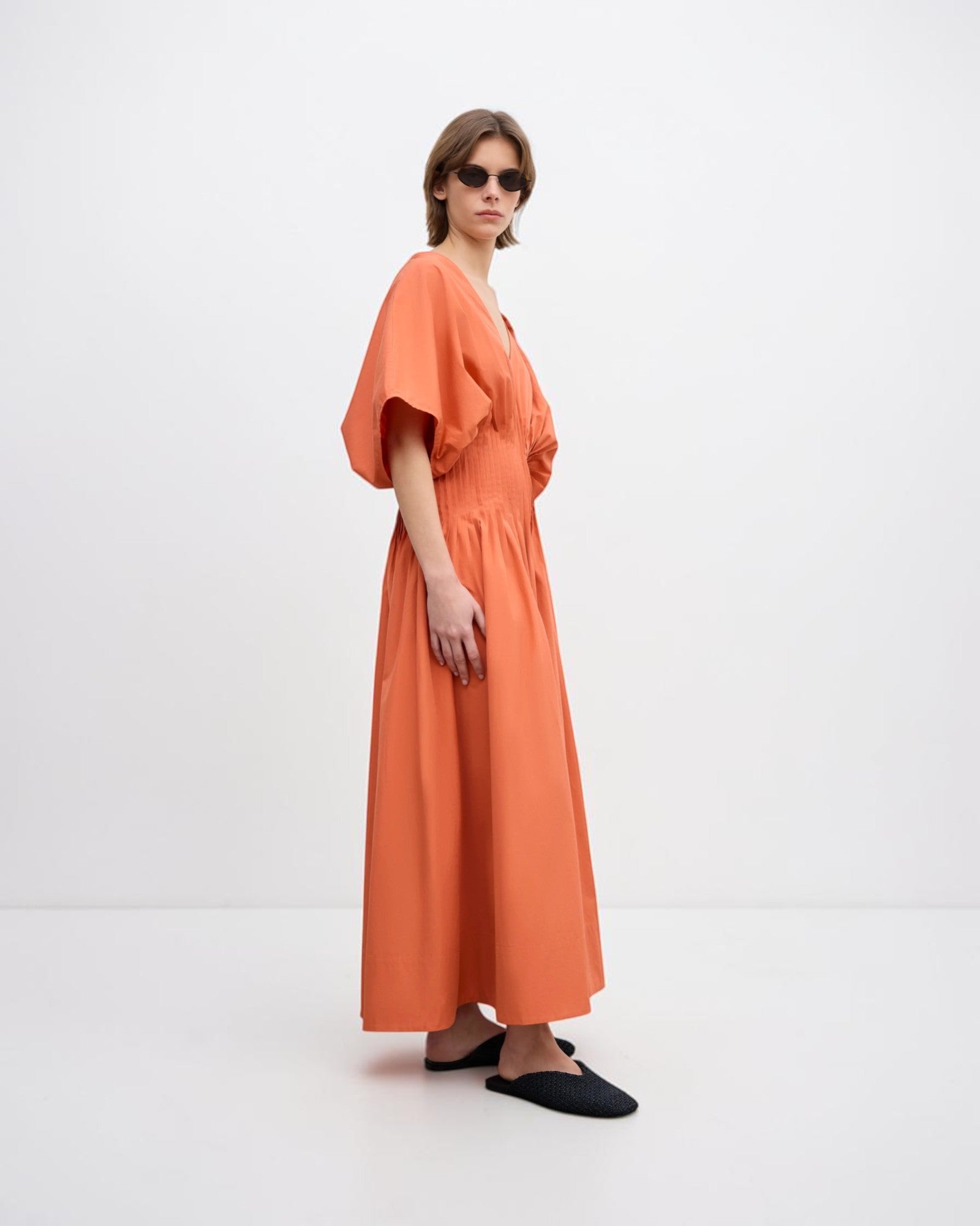 Dagmar Popelinekleid mit V-Ausschnitt in Orange seitlich getragen