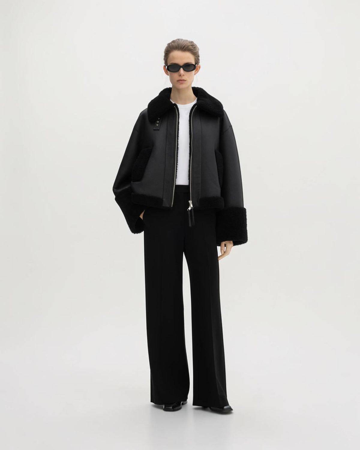 House of Dagmar schwarze Lammfelljacke offen am Model mit weiter schwarzer Hose in der Ganzkörperansicht
