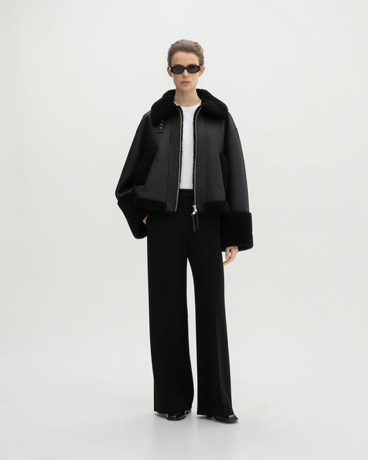 House of Dagmar schwarze Lammfelljacke offen am Model mit weiter schwarzer Hose in der Ganzkörperansicht
