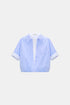 Light blue and white layered cropped blouse with a chest pocket, turn-up cuffs and gathered hem, front view.
