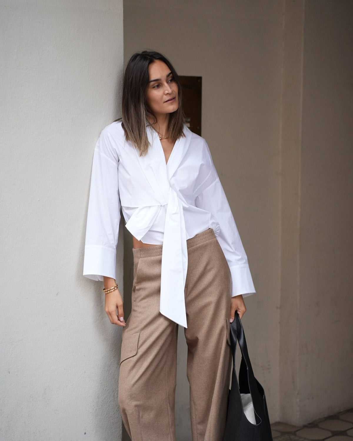 White Dorothee Schumacher poplin blouse with a tie detail on a model, front view.