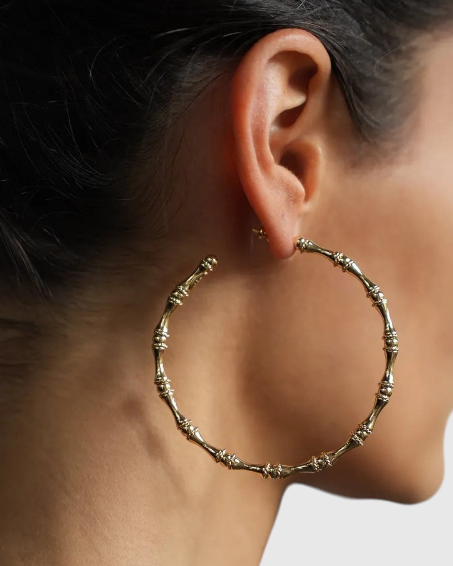 Detail der Gas Bijoux Creolen Bambou Large in Gold am Ohr
