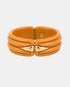 Orange acetate bangle with sculpted ridges and two gold-tone front accents, front view.