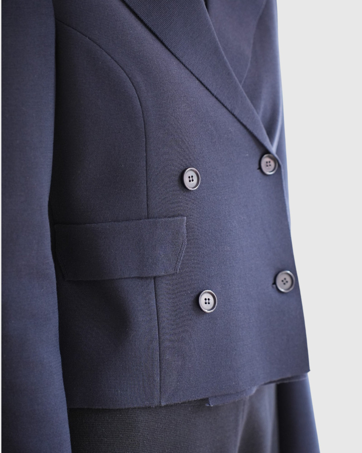 Detail von Strickstruktur, Revers und Knöpfen des marineblauen MRZ-Blazers