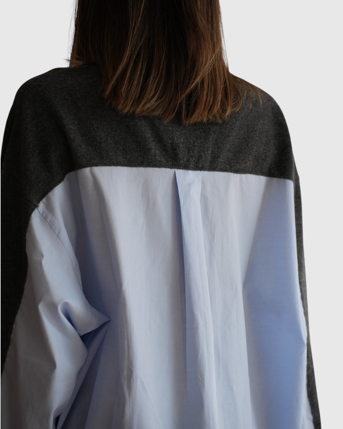 Detail des hellblauen Hemdrückens mit Mittelfalte und grauer Strickpartie am MRZ-Cardigan