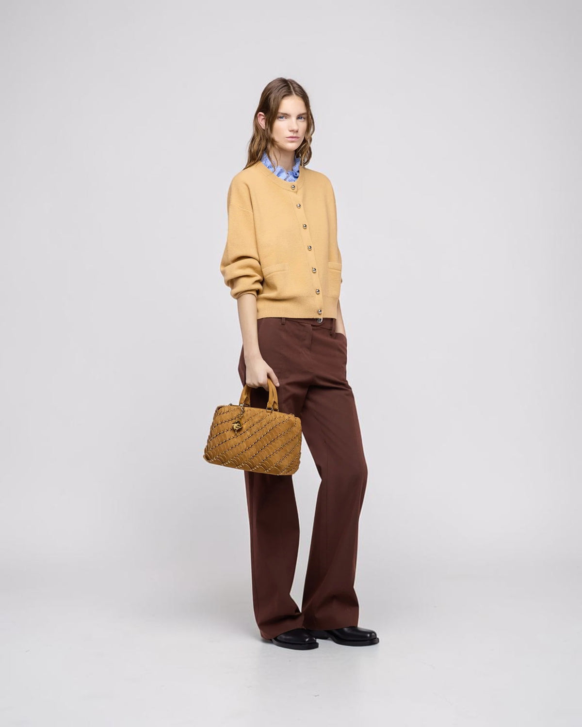 Rabanne Boston-Tasche in Camel am Model in der Hand getragen zu einer braunen Hose