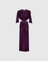 Deep purple jersey dress with draped sleeves, gathered fabric and a ring-linked cut-out waist, front view.