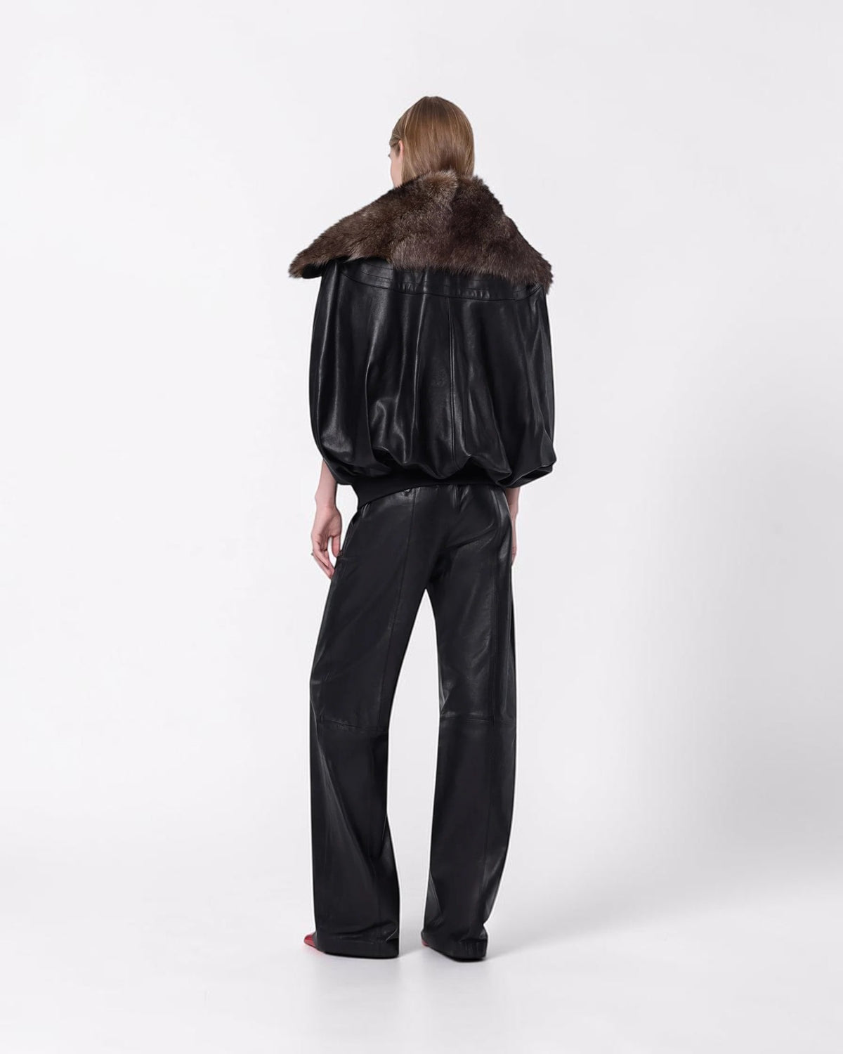 Rabanne Leder-Cape in Schwarz mit Lammfellkragen am Model von hinten