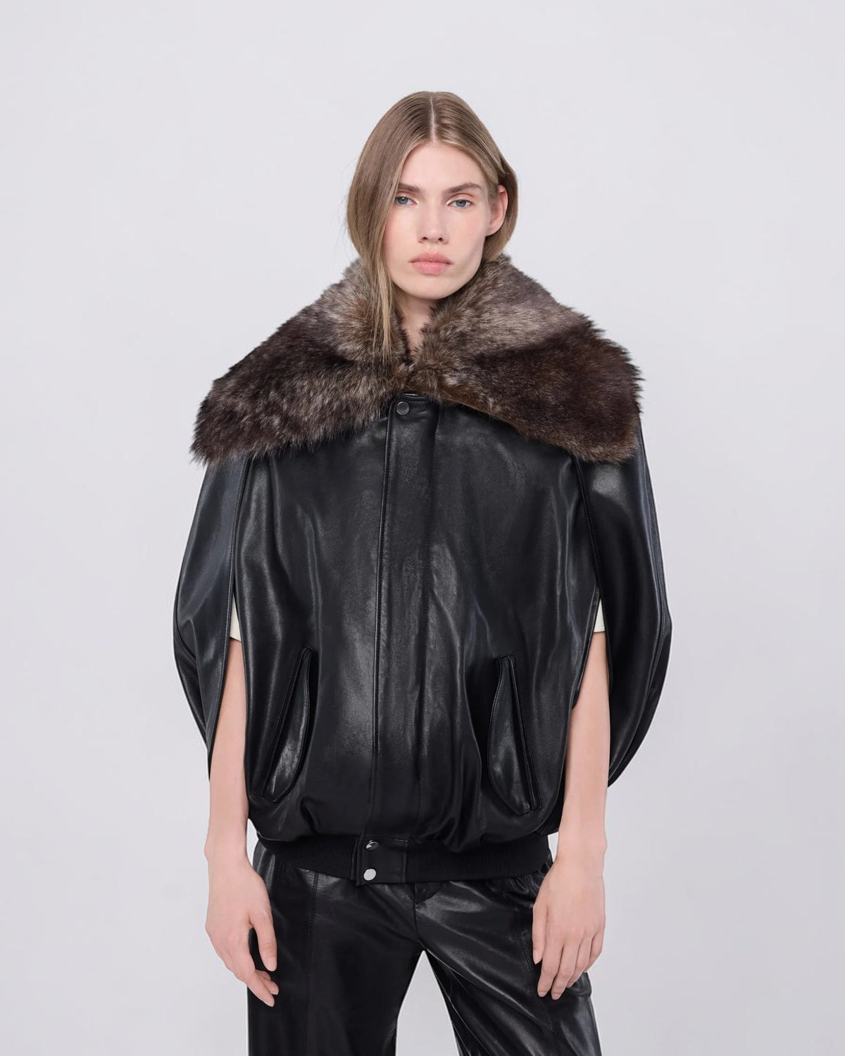 Rabanne Leder-Cape in Schwarz geschlossen am Model mit breitem Lammfellkragen in Nahansicht