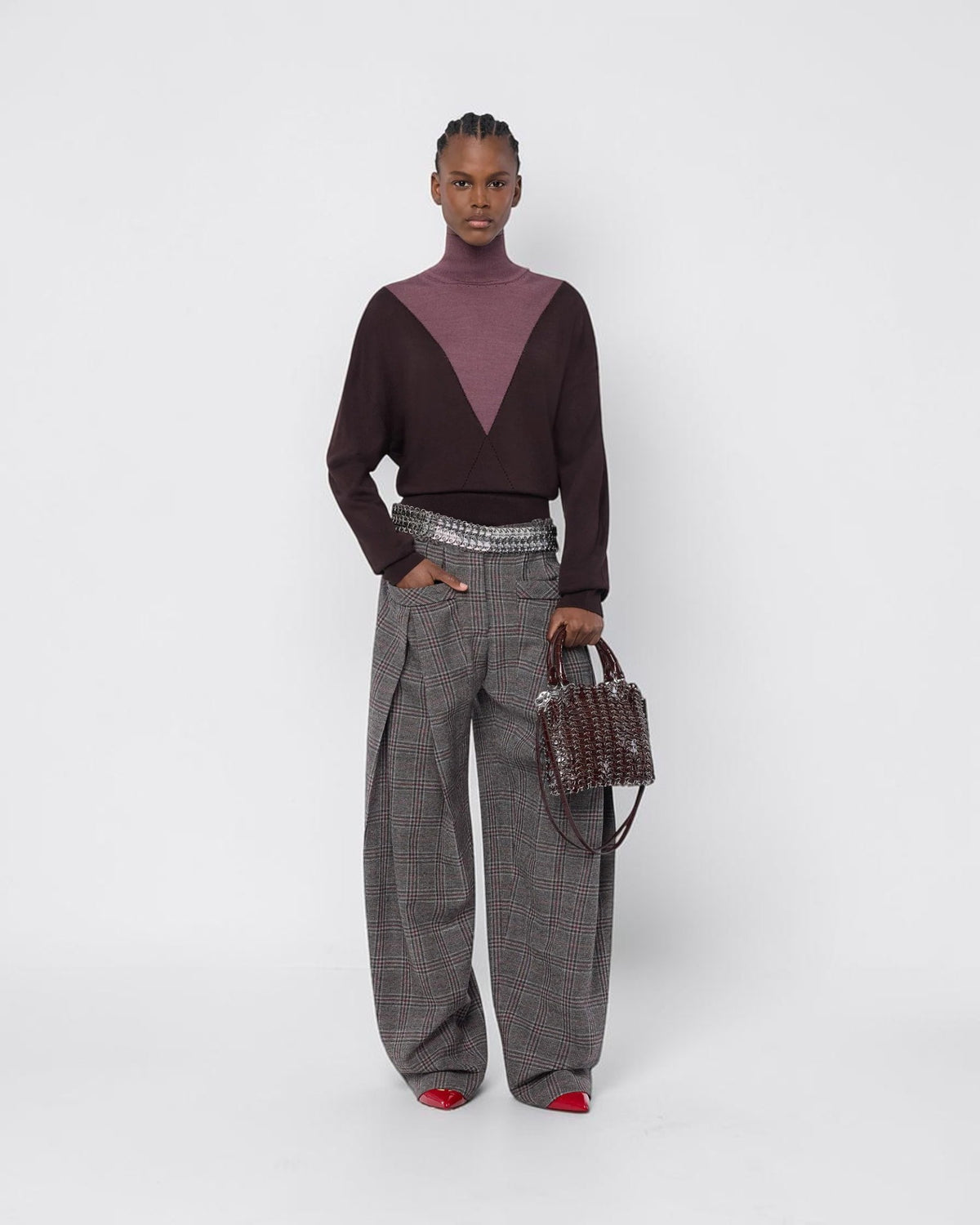 Rabanne Bicolor-Rollkragenpullover in Braun und Lila am Model von vorne zu einer weiten karierten Hose