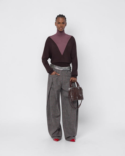 Rabanne Bicolor-Rollkragenpullover in Braun und Lila am Model von vorne zu einer weiten karierten Hose