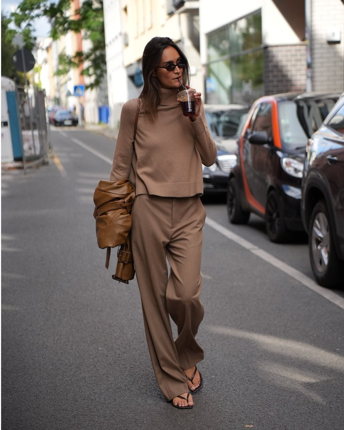 Model mit dunkelbeiger High-Rise Straight-Leg Hose von Vince beim Gehen, Vorderansicht.
