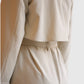Detail des Vince Trenchcoats in French Beige mit Rückenübertritt und Schlitz