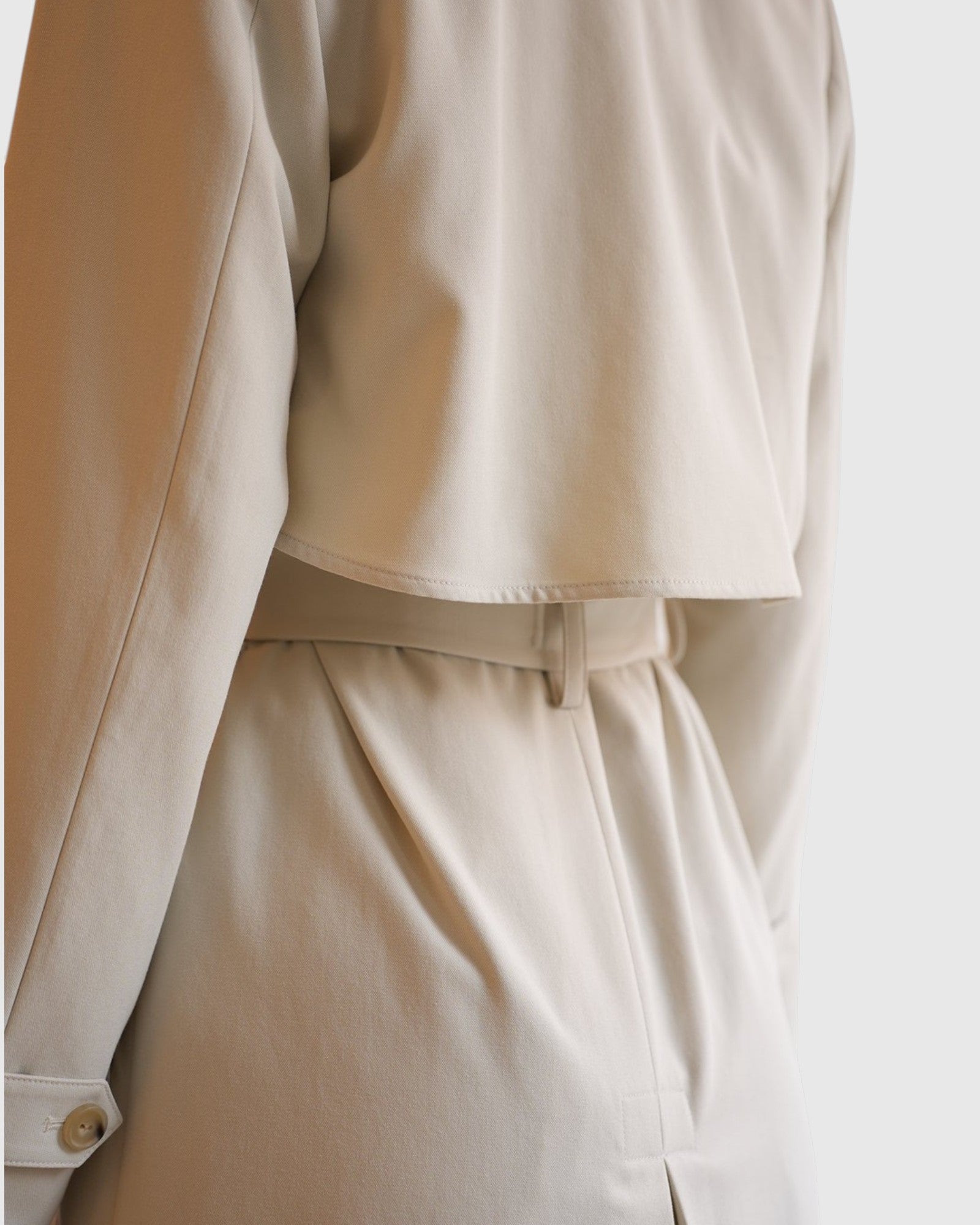 Detail des Vince Trenchcoats in French Beige mit Rückenübertritt und Schlitz